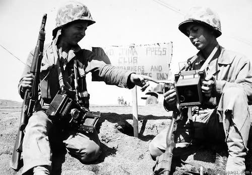 Iwo Jima in 1945 two cameramen with a Model 1897 pump action shotgun trench gun.