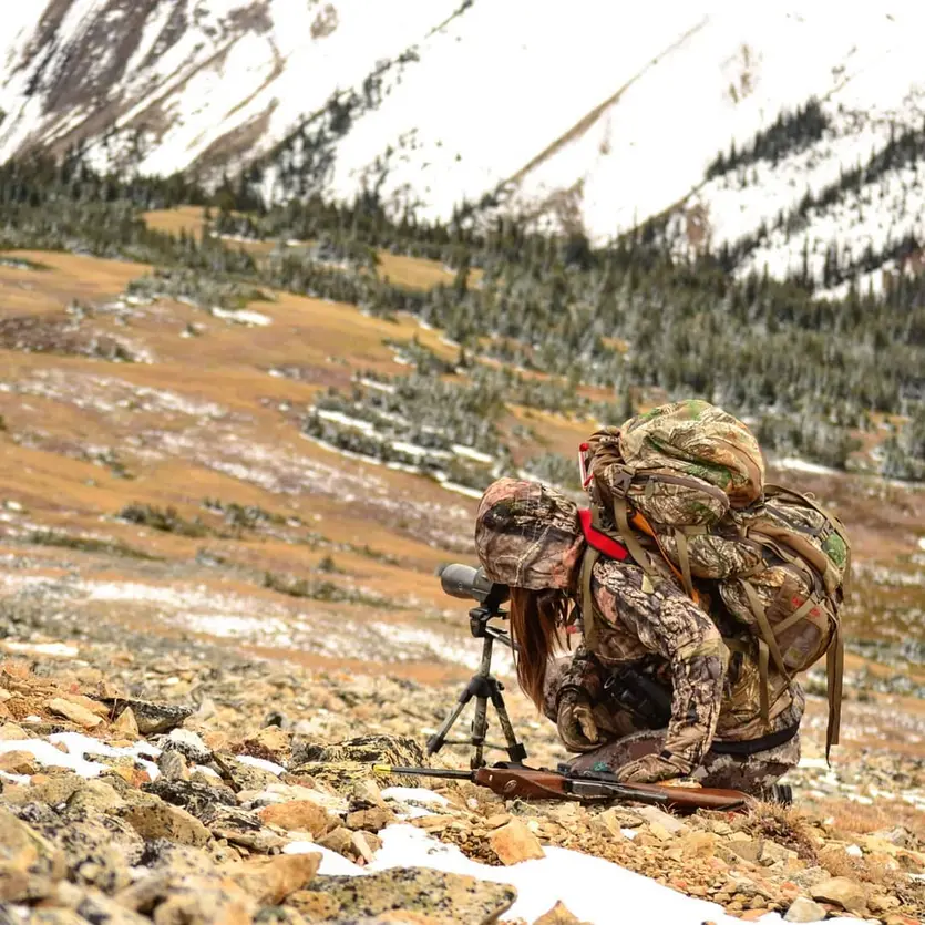 Hunter using spotting scope with BLR lever action rifle