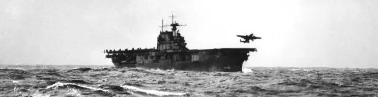 US Aircraft carrier with plane taking off.