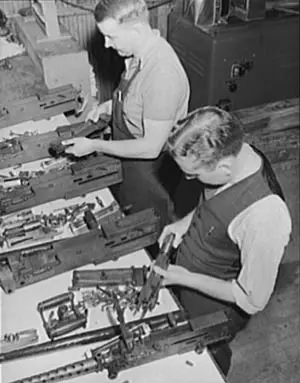 Workmen assemble Browning .30 and .50 caliber aircraft machine guns. 