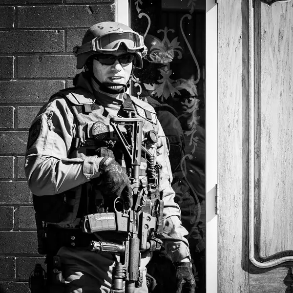 Jared Wihongi in SWAT gear holding rifle
