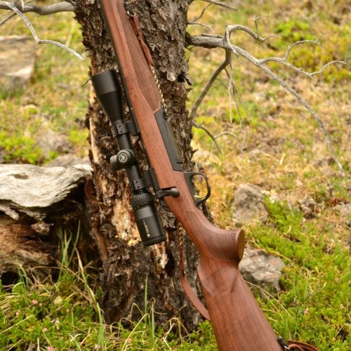 X-Bolt bolt action rifle leaning against tree