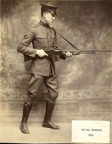 Lt. Val Browning in uniform holding BAR rifle.