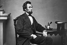 Abraham Lincoln sitting at a table.