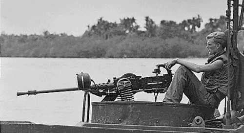 A US Navy “Brown Water” sailor mans his .50 caliber Browning during Vietnam.