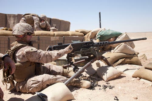 A Marine racks a round into his .50 caliber Browning M2HB on the training range at Camp Leatherneck in Helmand Province, Afghanistan.