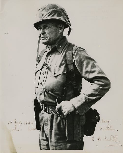 Sporting his trademark pipe and a Model 1911 pistol, Chesty Puller 