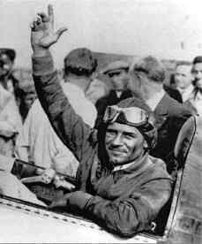 A young Jimmy Doolittle waves from the open cockpit of a racing plane in the 1930s.