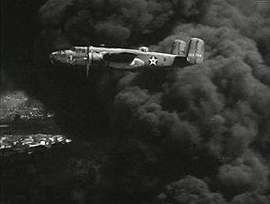 B25 bomber flying over black smoke