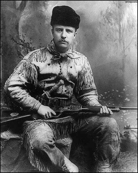 Theodore Roosevelt poses with his favorite Winchester Model 1876 rifle in a studio photo about 1884.