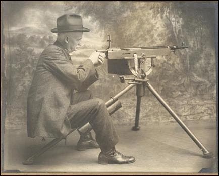 John M. Browning displays one of his Model 1895 “Potato Digger” machine guns. 