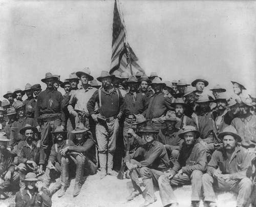 Lt. Col. Roosevelt and his Rough Riders pose with the US flag in Cuba, 1898. 