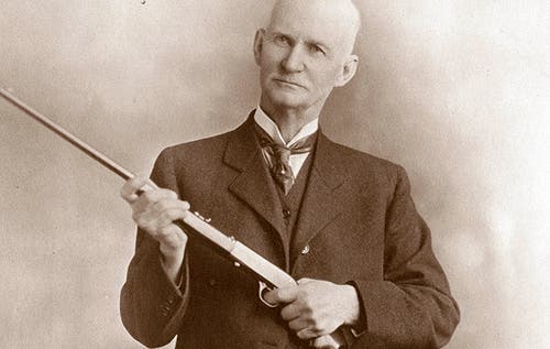 John M. Browning holding SA-22 semi-auto rimfire rifle.