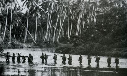 Soldiers wading through water on Guadalcanal