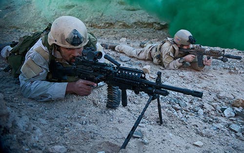 A US Navy SEAL takes aim with his FN-built MK48 7.62mm machine gun. 