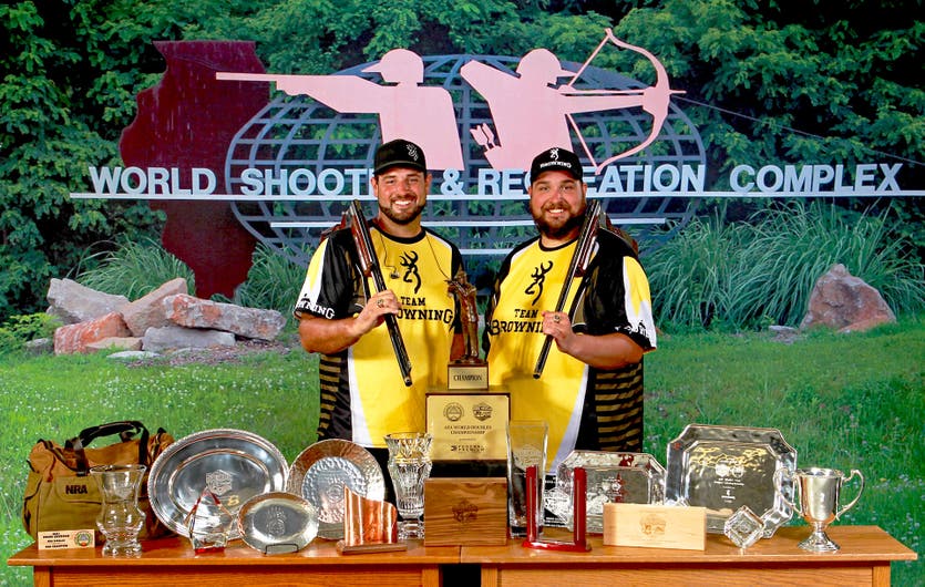 Matt and Foster Bartholow with shotguns and trophies from 2021 Grand American