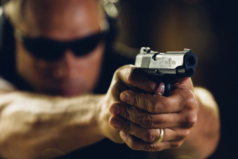 Man shooting a 1911-380 pistol.